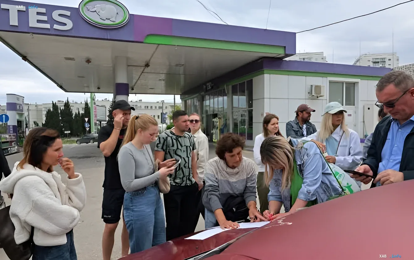 Warteschlange von Fahrern an einer Tankstelle in Sewastopol, wo Menschen Dokumente ausfüllen und QR-Codes scannen, um Kraftstoff aufgrund eingeführter Limits zu erhalten.