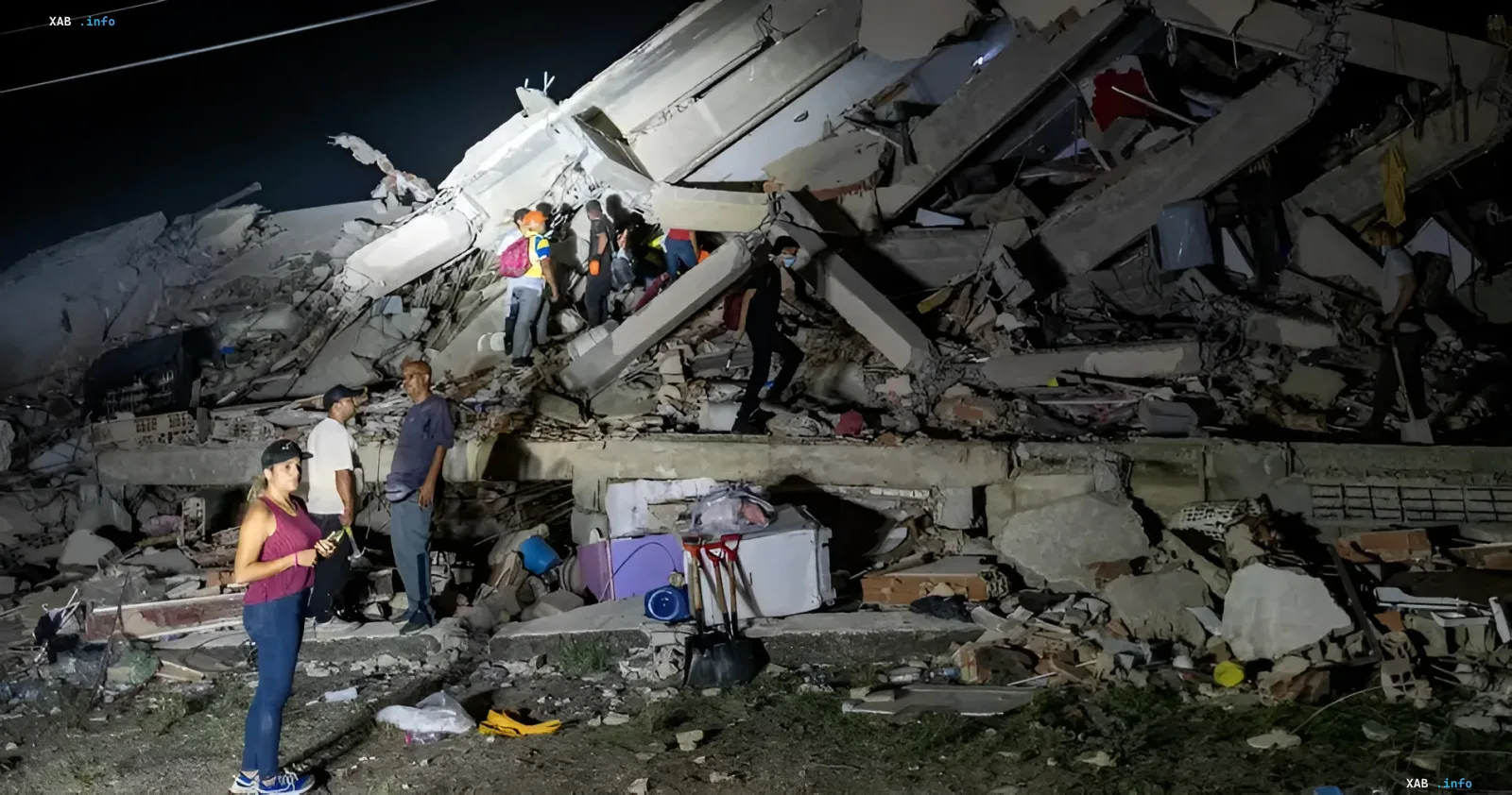 Collapsed building after earthquake in Venezuela: people and rescuers among rubble at night