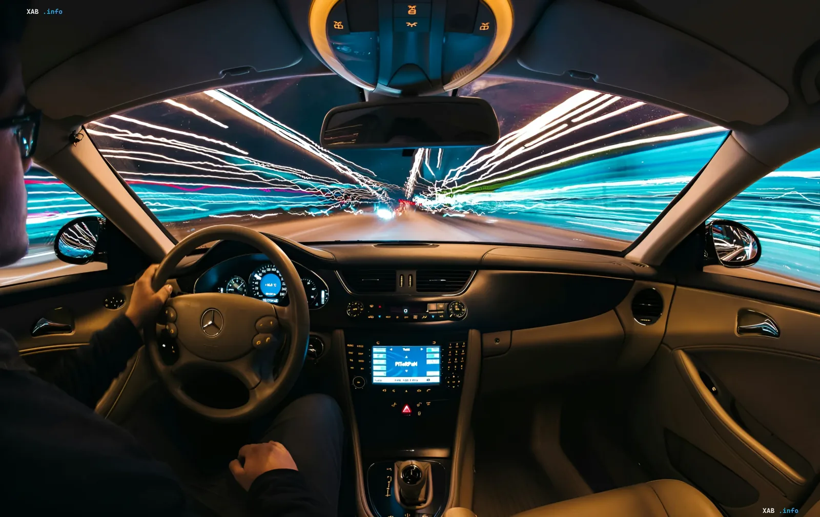 Ansicht aus dem Inneren eines Autos mit aktiviertem Autopiloten, die verschwimmende Lichter einer nächtlichen Stadt durch die Windschutzscheibe zeigt und die Einschränkungen von Erkennungssystemen veranschaulicht