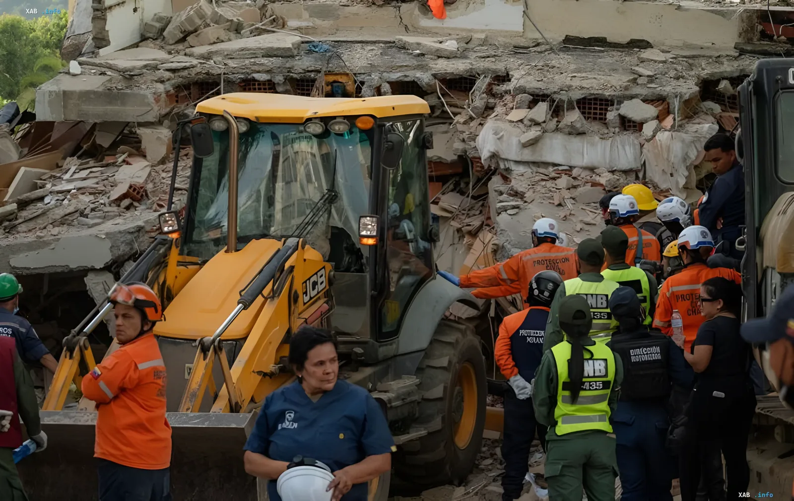Rescuers in orange vests and yellow JCB machinery work among the ruins of a building after an earthquake in Venezuela