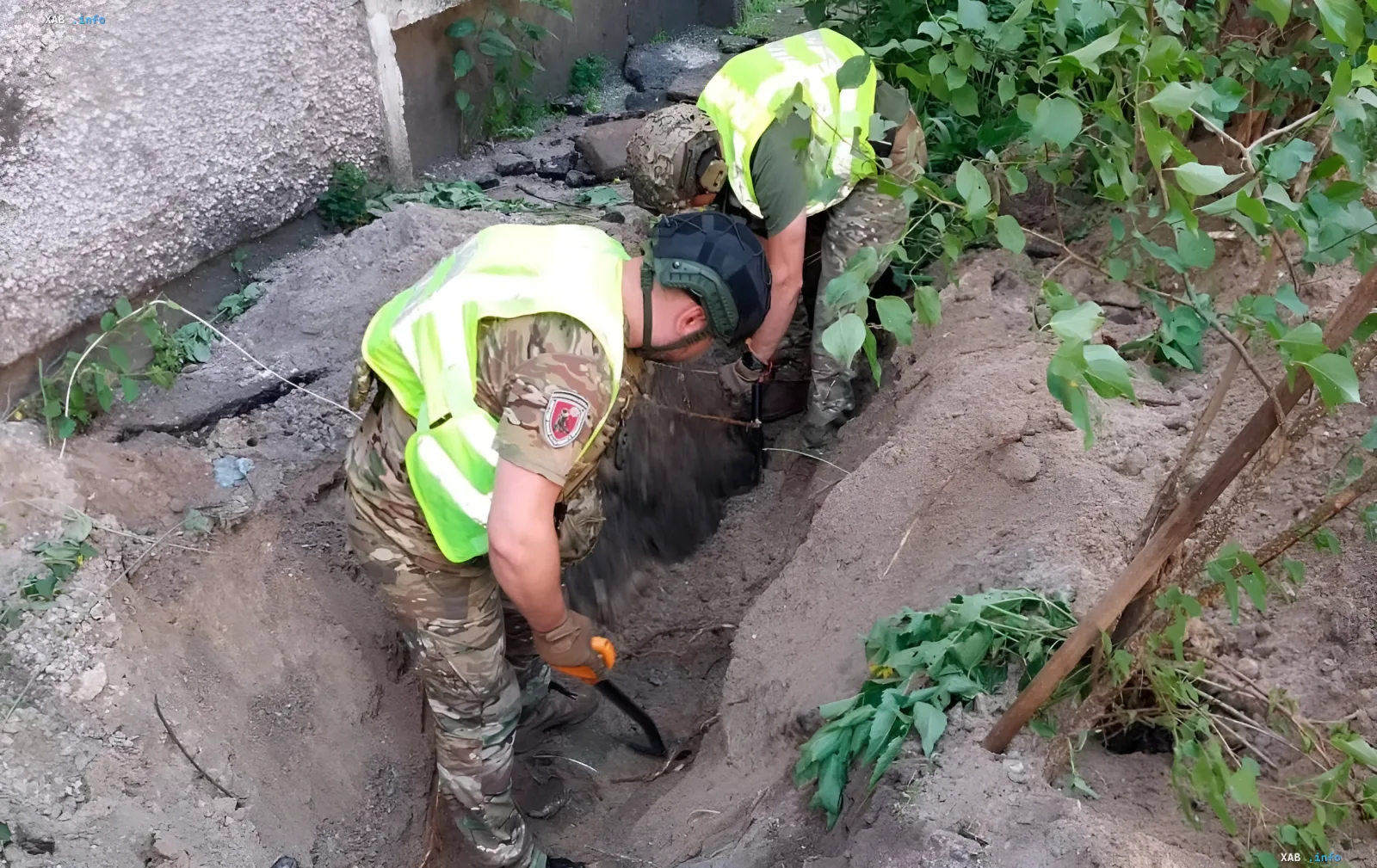Rescuers in protective vests extract a rocket warhead from the ground near a residential building in Kyiv after a night attack
