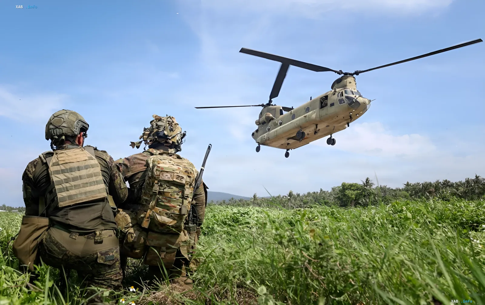 Британский транспортный вертолет Chinook в воздухе, солдаты наблюдают за посадкой в поле