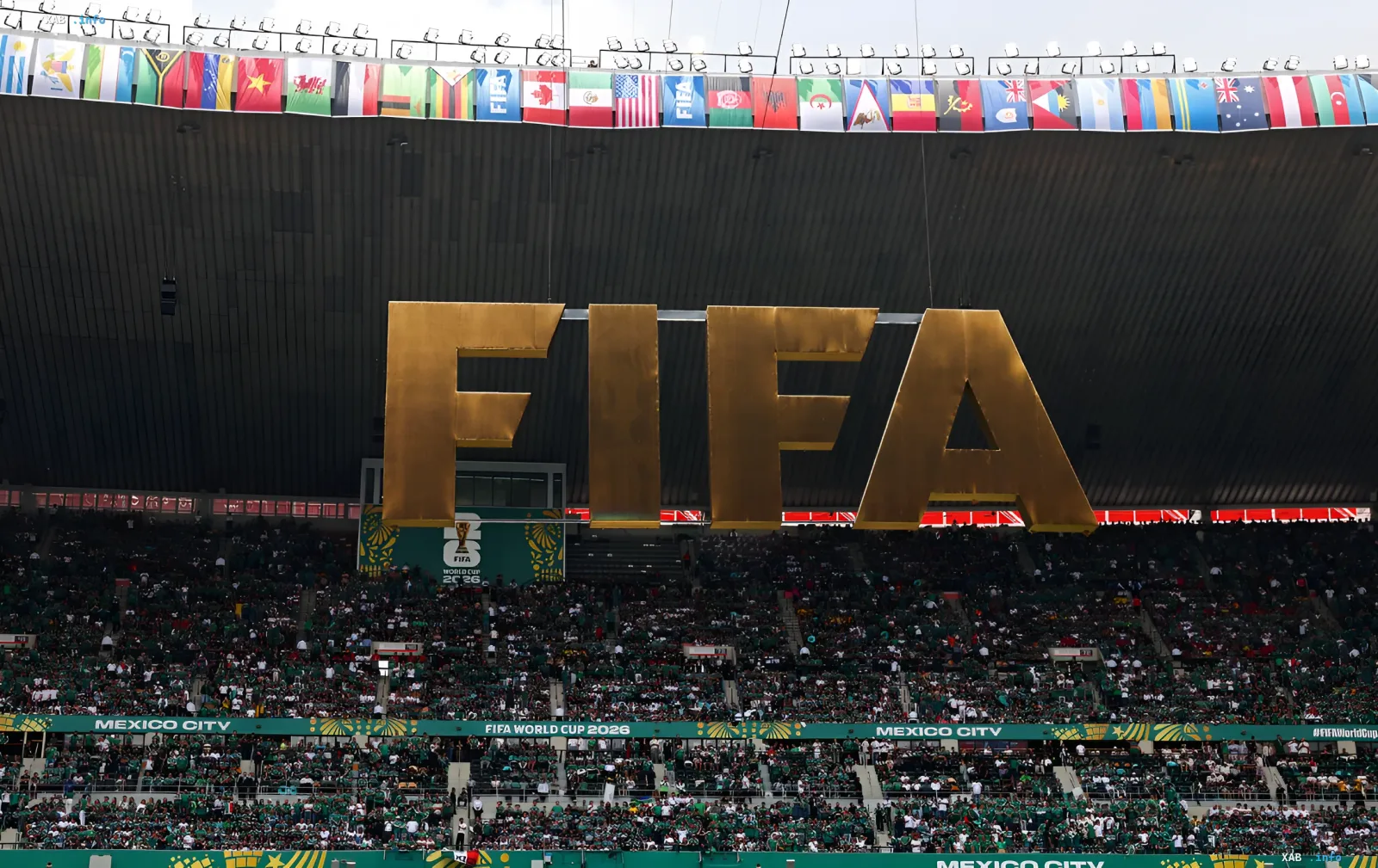 Стадион в Мехико с гигантским золотым логотипом FIFA и флагами стран-участниц ЧМ-2026 на фоне трибун, заполненных болельщиками в зелёных футболках — символ глобального турнира, где Колумбия и ДР Конго совершили исторические прорывы