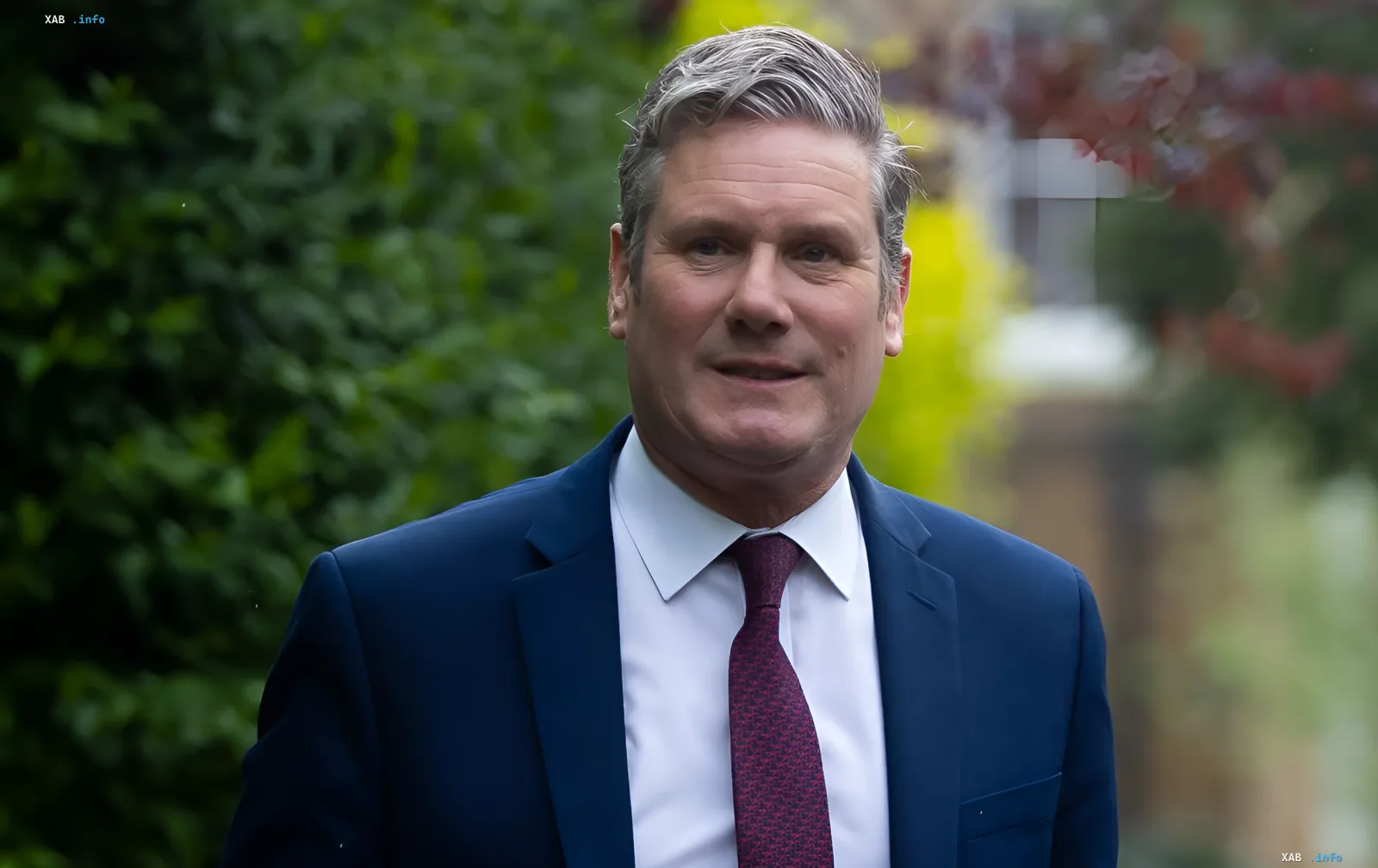 Keir Starmer in einem Anzug vor einem grünen Hintergrund, der seine Ambitionen symbolisiert, NATO-Generalsekretär zu werden