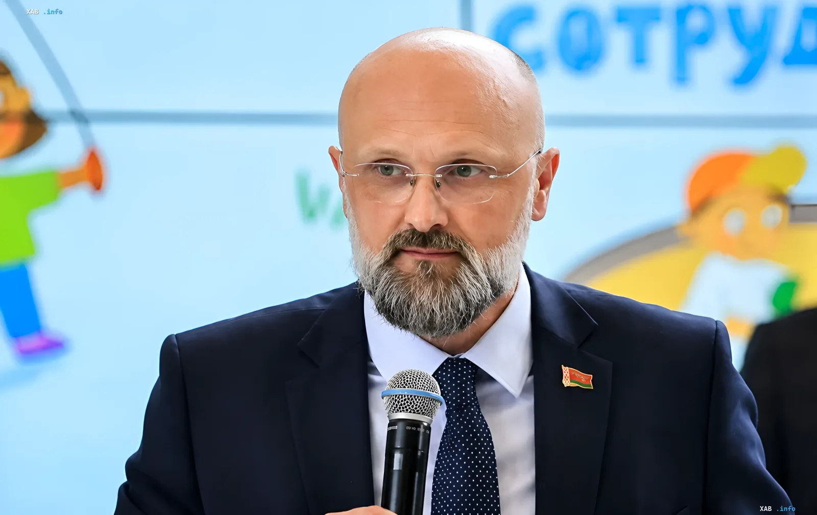 Министр обороны Беларуси Виктор Хренин с микрофоном на фоне плаката с надписью «СОТРУДНИЧЕСТВО», символизируя официальное заявление о готовности ответить на пересечение границы с Украиной