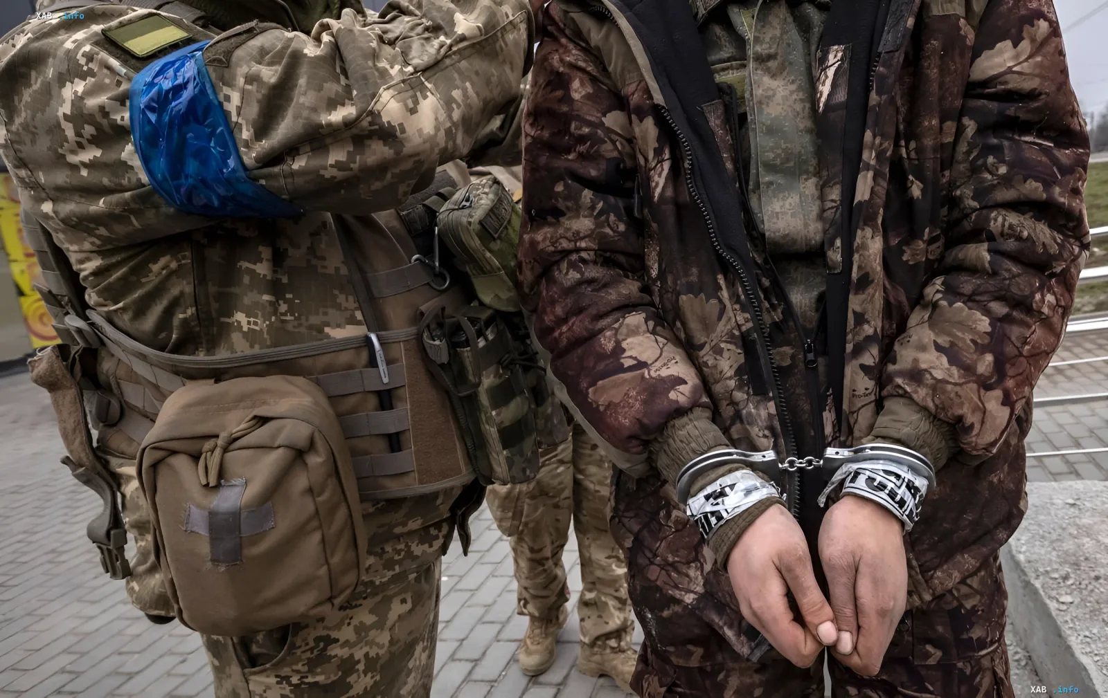 Verhafteter russischer Soldat in Handschellen neben einem ukrainischen Soldaten in der Richtung Pokrowsk
