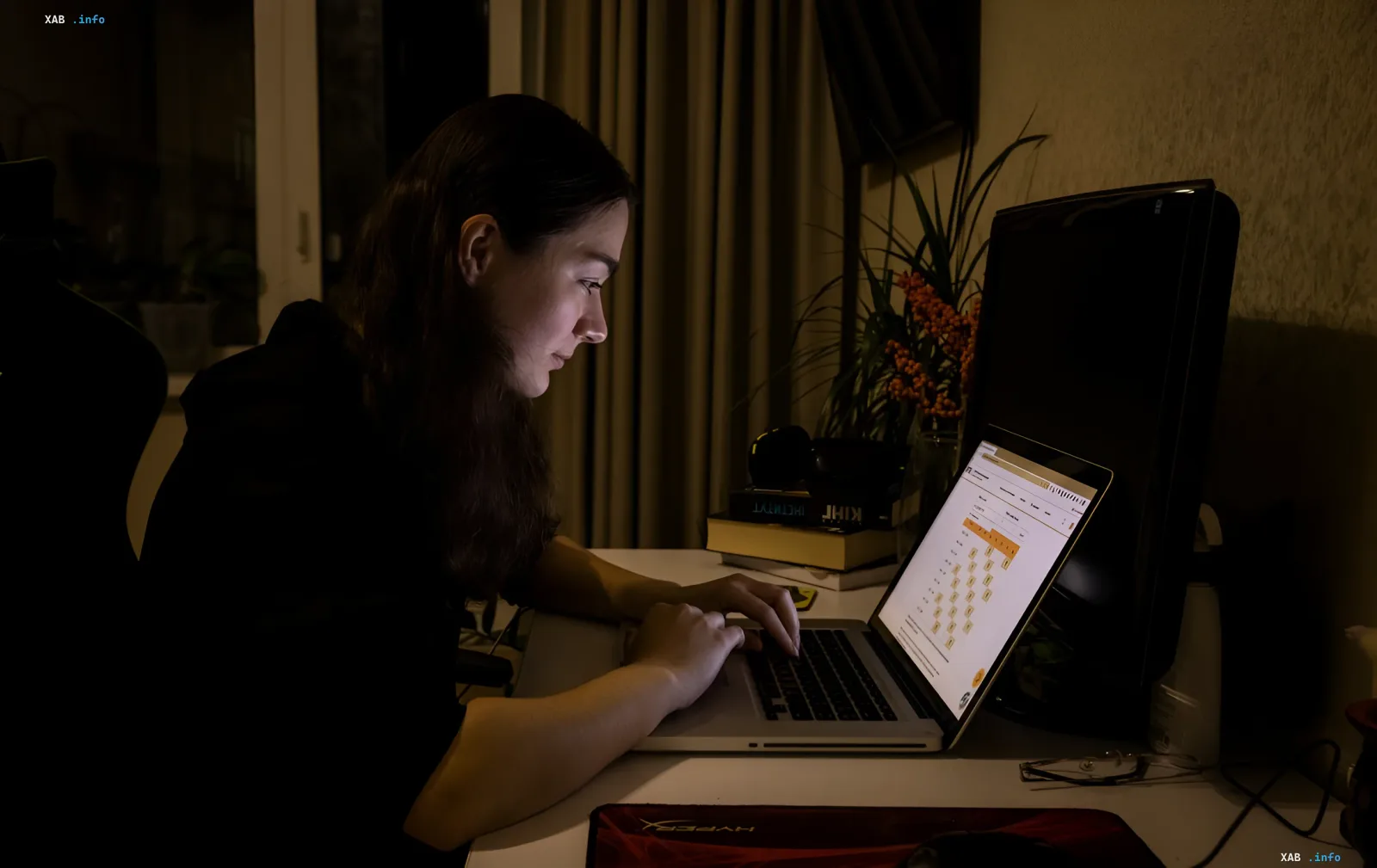 Woman working on a laptop in the dark, symbolizing power outages in Ukraine due to heat and war