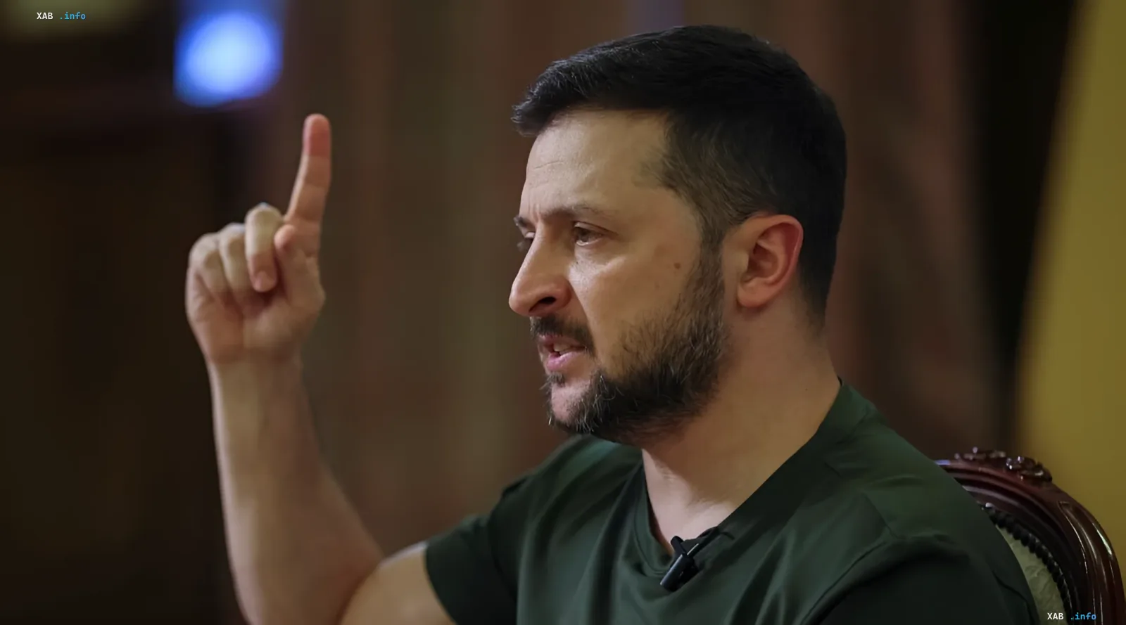 Ukrainian President Volodymyr Zelenskyy in a green T-shirt gestures with his finger pointing up while discussing the new law on the national pantheon and memory of heroes