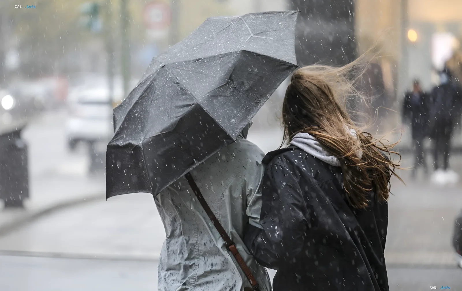 People under an umbrella during strong wind and rain in Lviv during a hurricane