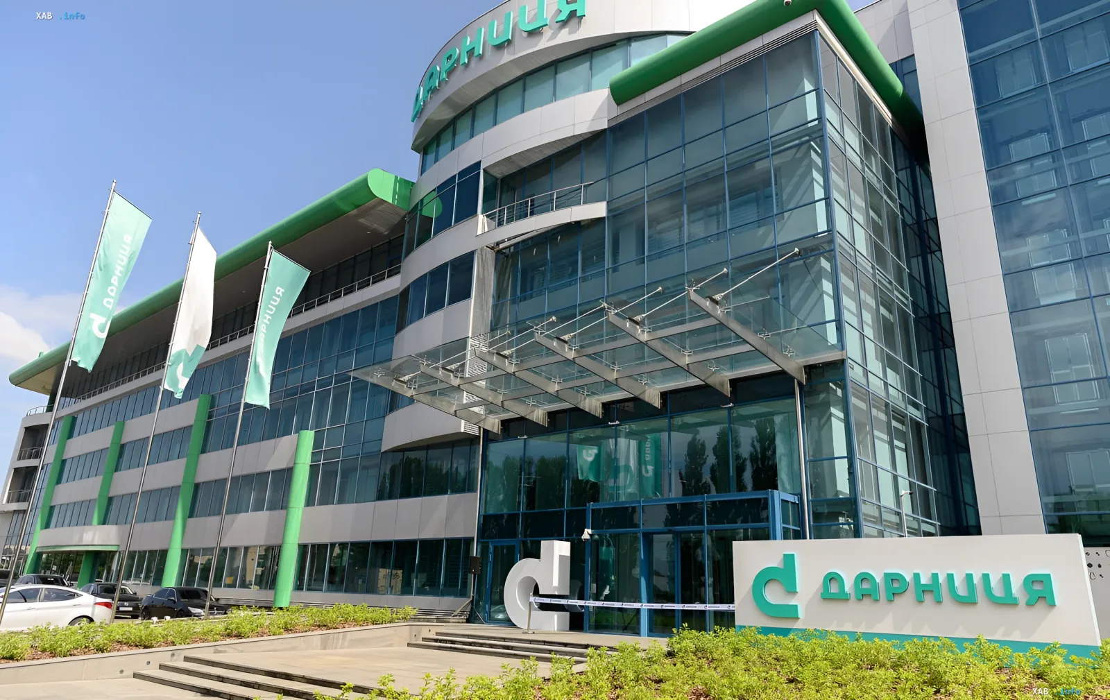 Gebäude des Pharmakonzerns «Darnitsa» mit grünen Flaggen und moderner Fassade, das die ununterbrochene Arzneimittelproduktion nach dem Angriff symbolisiert