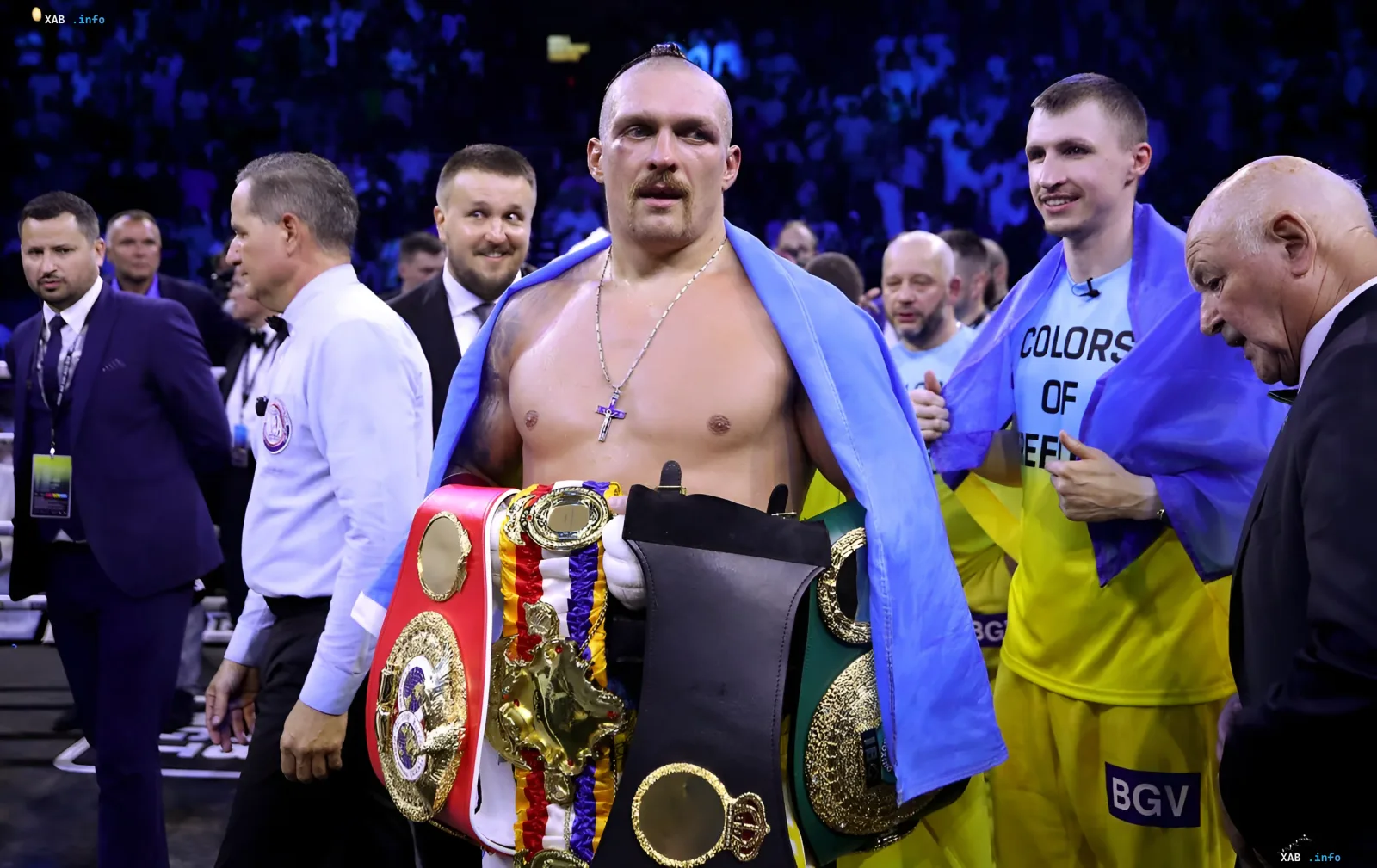 Оleksandr Usyk с поясами чемпиона мира и флагом Украины, символизирующий его статус, который теперь под угрозой из-за назначения IBF нового боя за вакантный титул