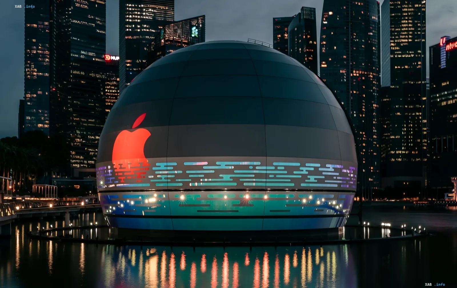 Футуристичное здание Apple с логотипом, освещенное неоновыми огнями, символизирующее обновление iOS 26.5.2 и устранение уязвимостей в Safari и ядре системы