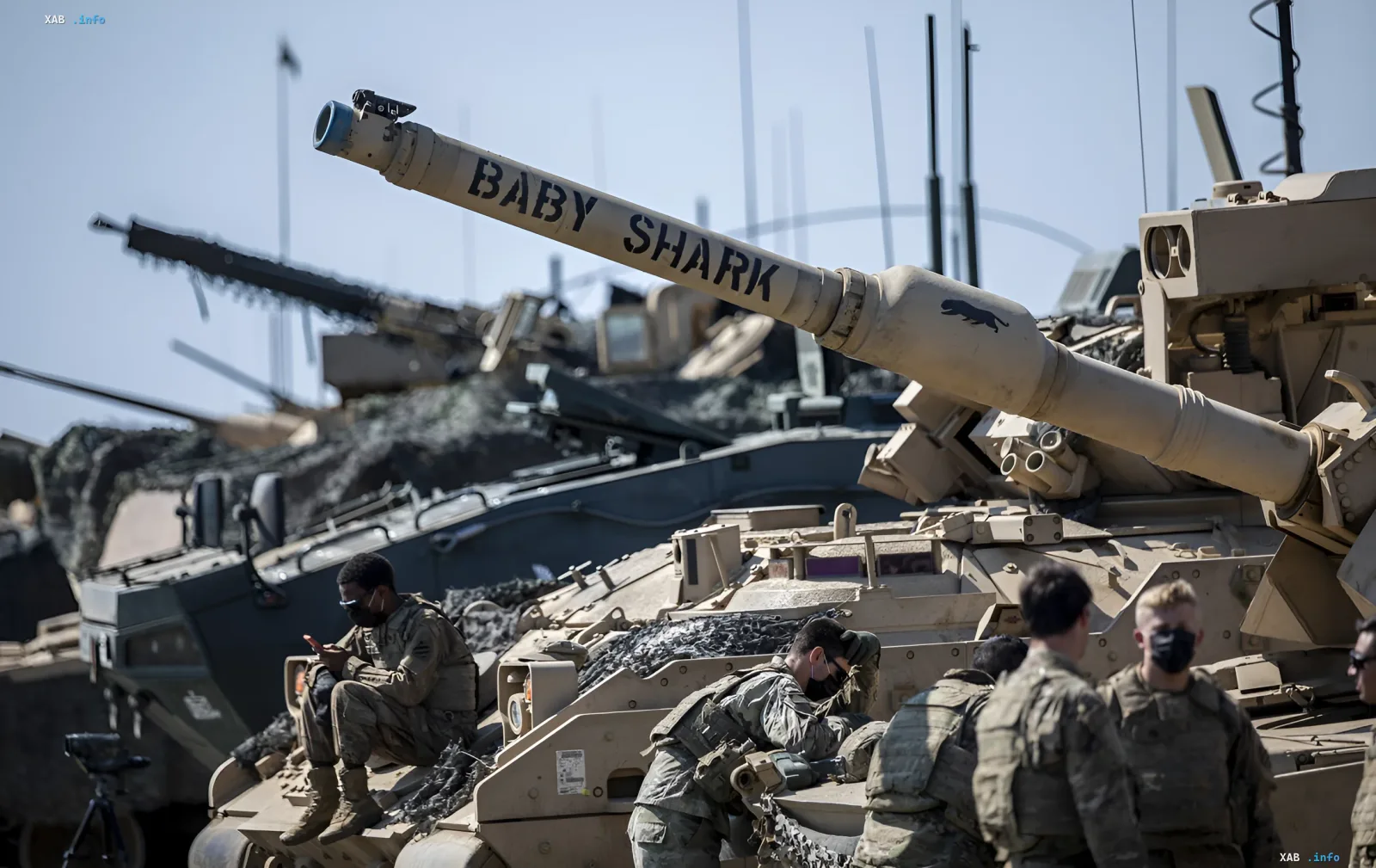 US Abrams tanks with 'Baby Shark' inscription and soldiers in camouflage during exercises, demonstrating US readiness to defend the Baltics