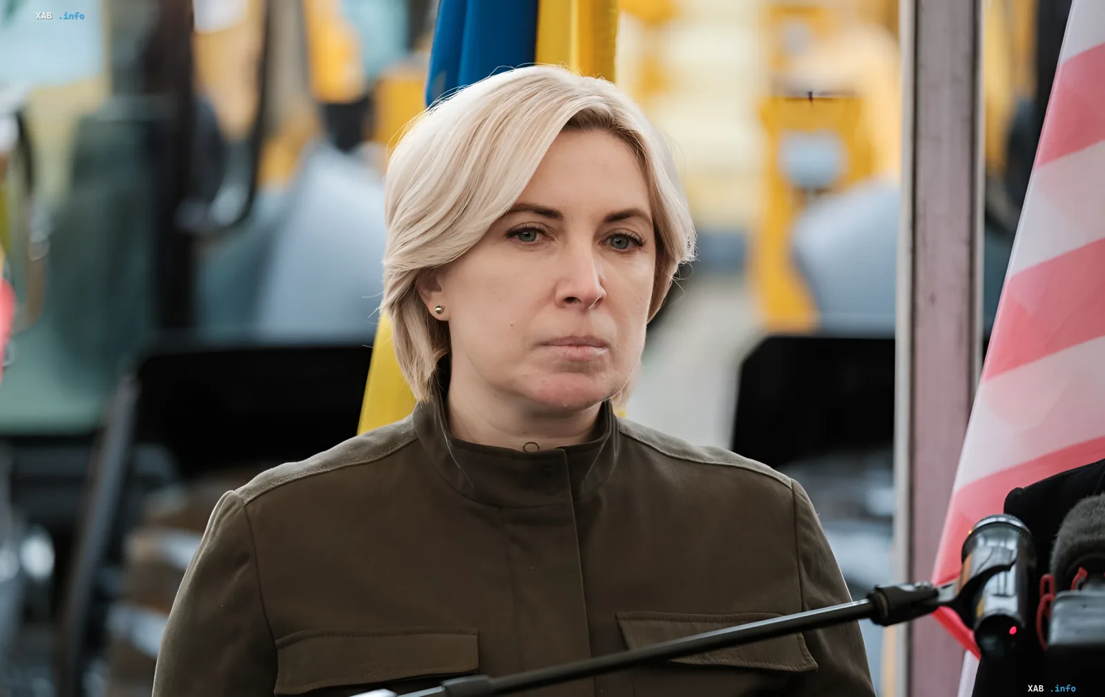 Ukrainian Defense Minister Olena Saluk speaking in front of the Ukrainian flag and military equipment, commenting on the new draft law introducing criminal liability for Ukrainophobia