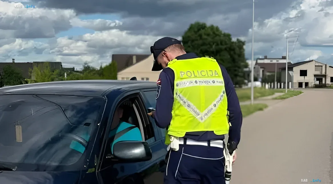 Latvian police officer checking documents at a car near the Russian embassy, illustrating new controls under diplomatic parity