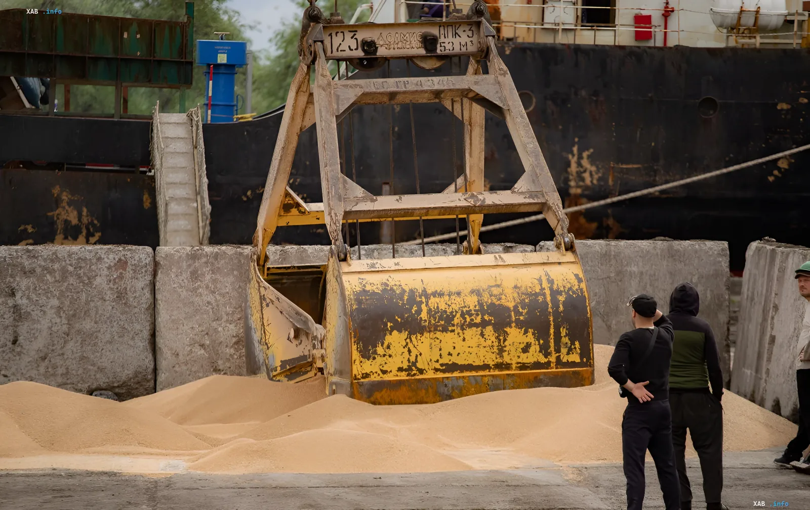 Beladung ukrainischen Getreides in einem afrikanischen Hafen: Bagger arbeitet mit Getreide, Beobachter überwachen den Prozess