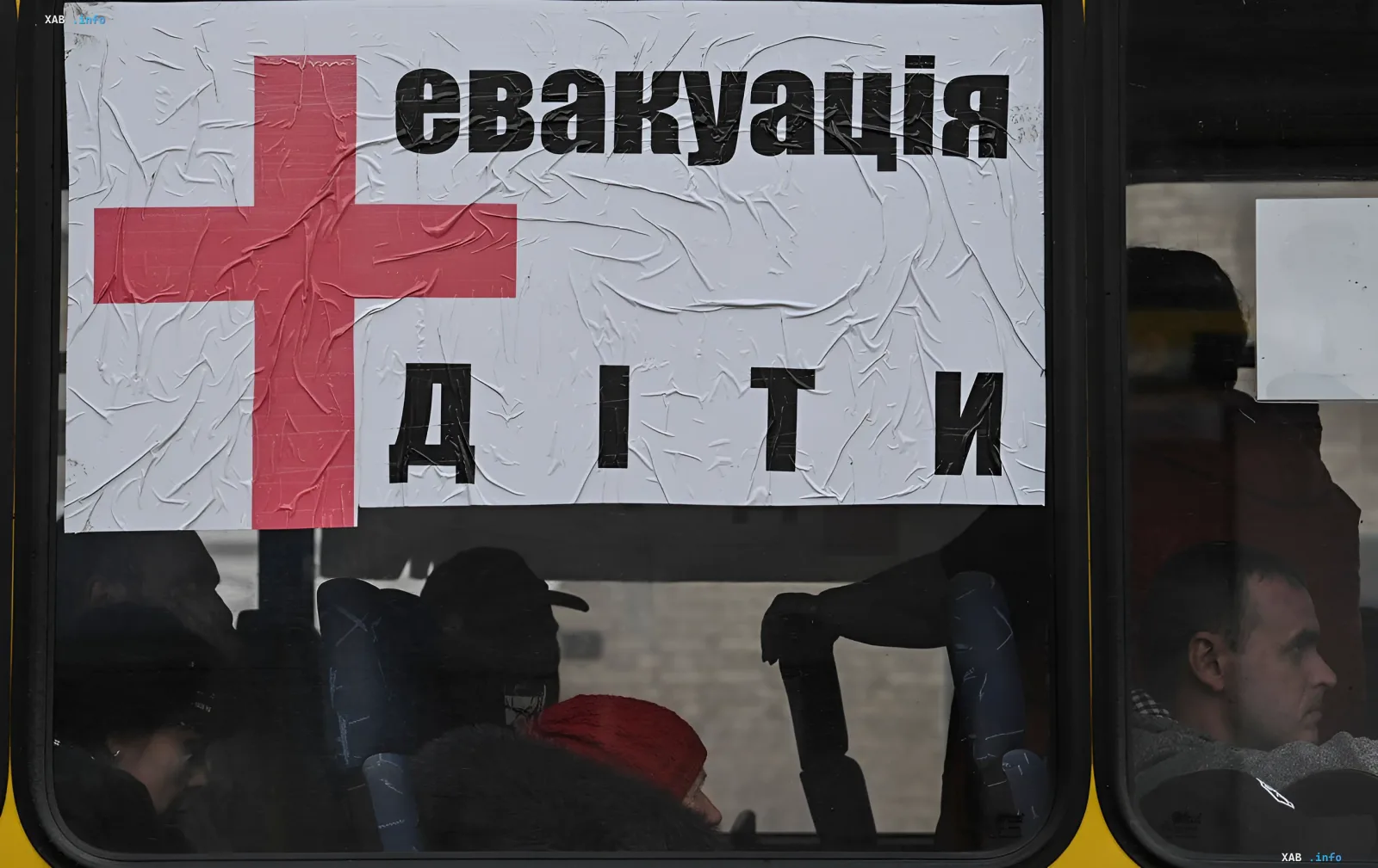 Bus with sign 'Evakuatsiia diti' and red cross transporting children as part of mandatory evacuation from border settlements in Kharkiv region