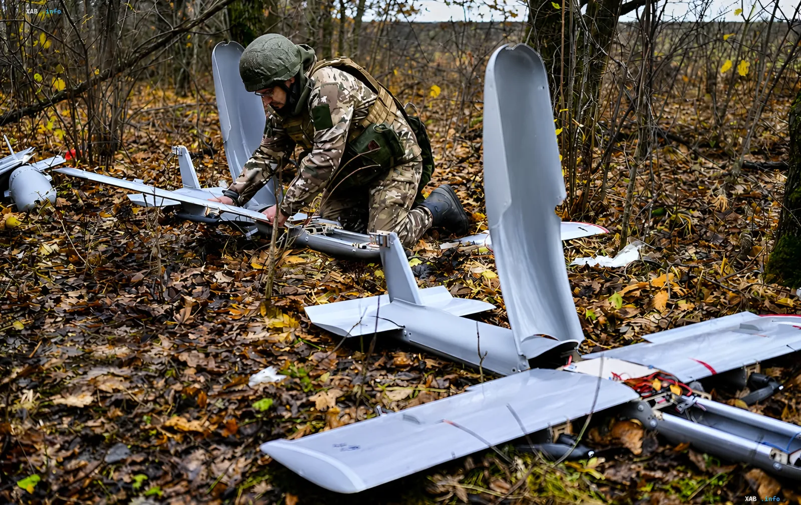 Российский военный собирает разбитый дрон Молния в лесу, демонстрируя переход на автономные системы с ИИ