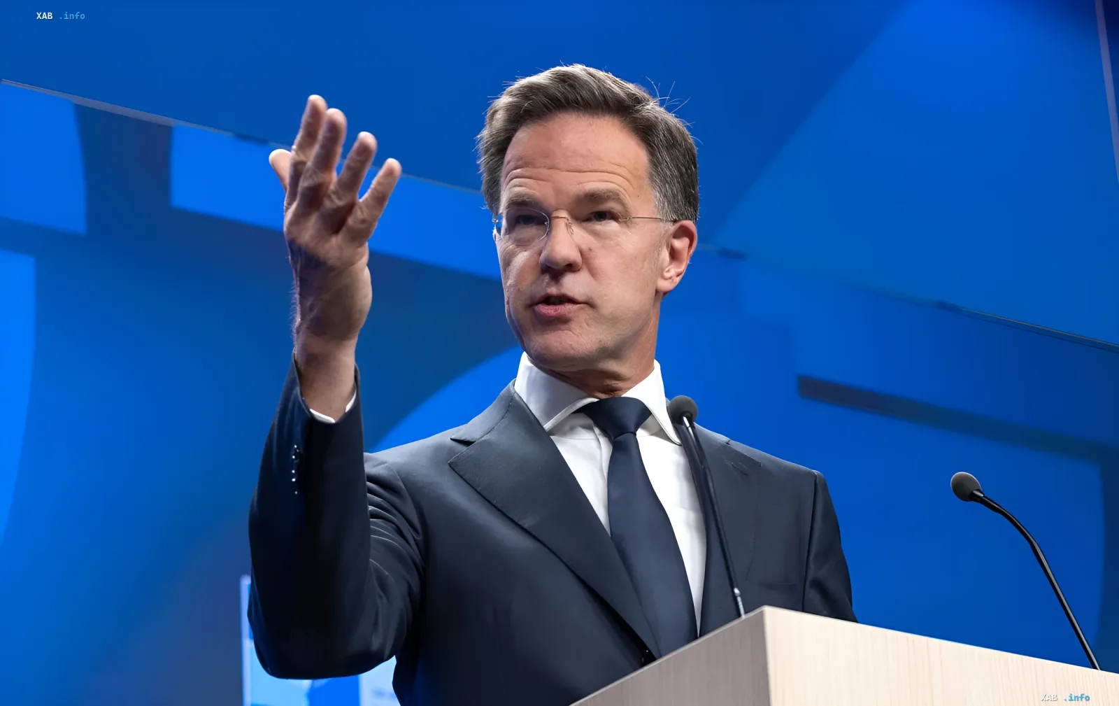 Mark Rutte speaking at a podium against a blue backdrop, gesturing with his hand — warns that Ukraine’s successes do not guarantee negotiations with Putin