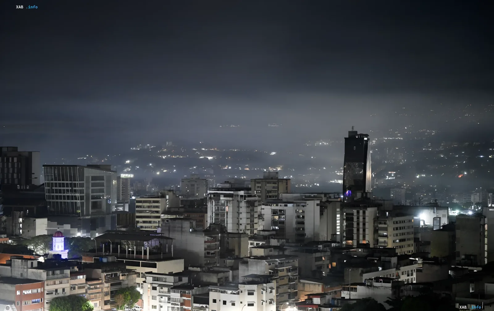 Night view of a city in Venezuela with thick fog and scattered lights, symbolizing destruction and crisis captured by NASA satellites