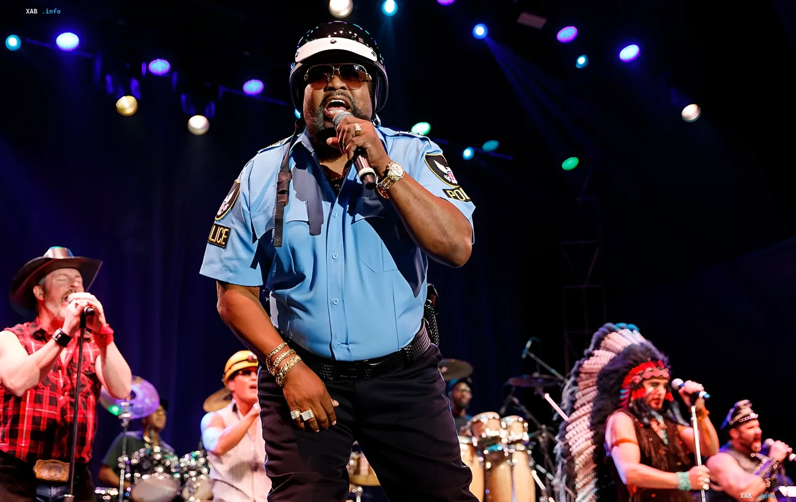 Виктор Уиллис в костюме полицейского на сцене с группой Village People, исполняет хит Y.M.C.A.