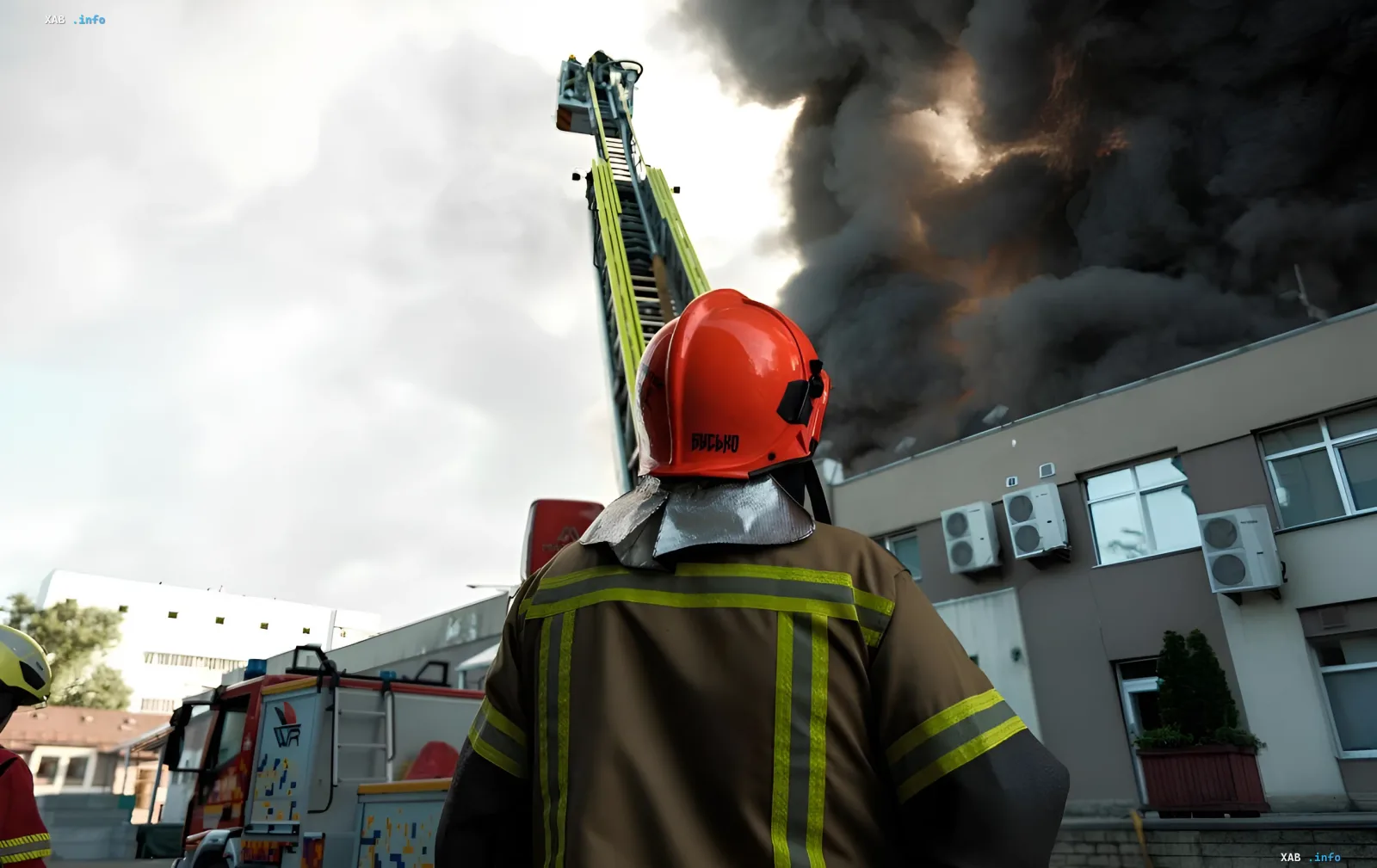Firefighter in protective gear observes thick black smoke from a building fire after attack on Kyiv; rescue operation under rubble