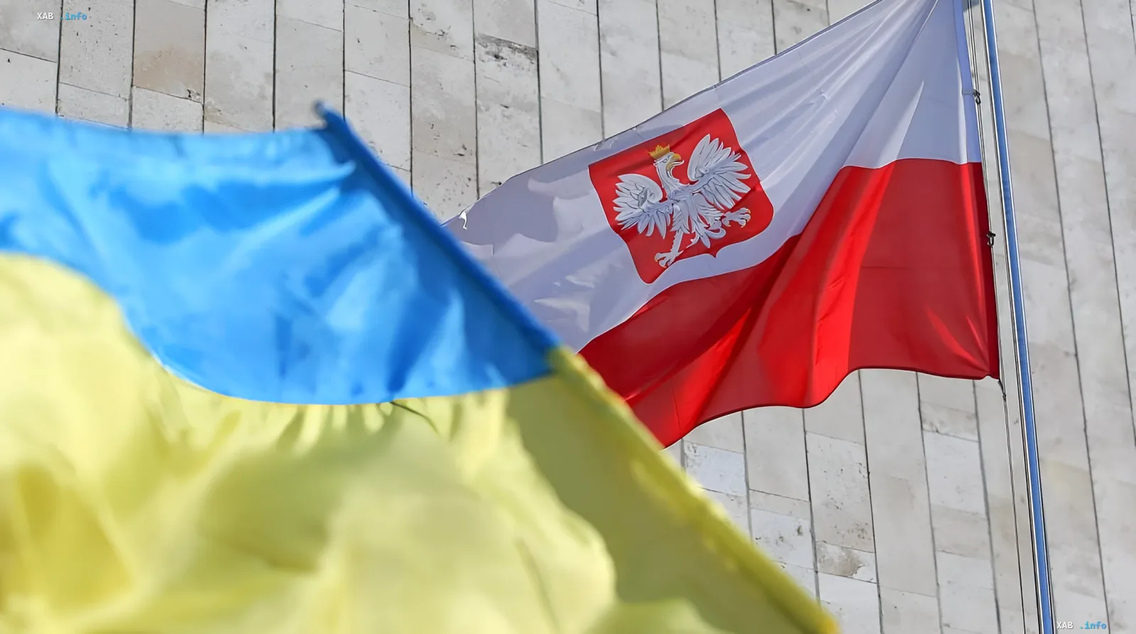 Флаги Украины и Польши на фоне здания, символизирующие сложные исторические отношения и спор о Волыни, влияющий на вступление Украины в ЕС