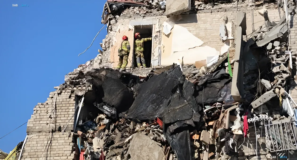 Rescuers work on the ruins of a destroyed building in the Darnytskyi district of Kyiv after the tragedy