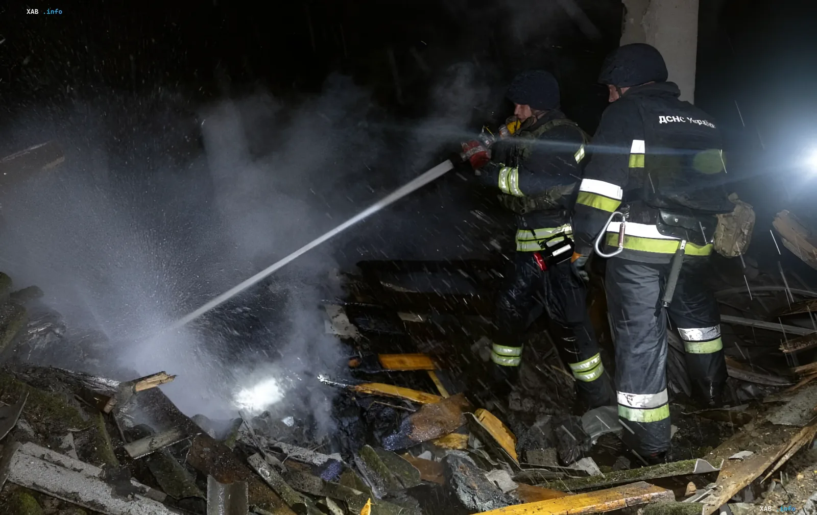 Firefighters extinguishing fire among debris after night missile strike on Kyiv
