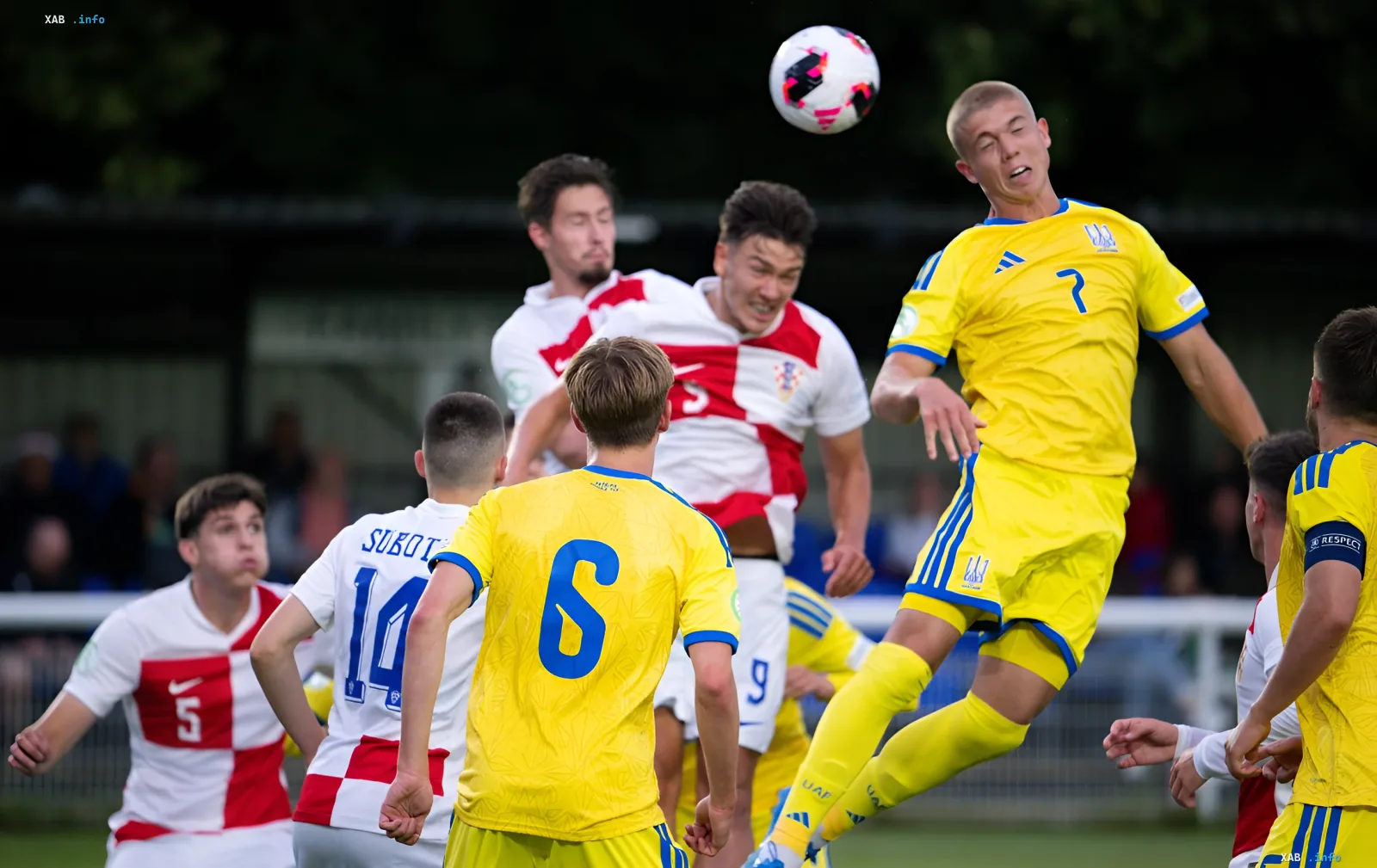 Игрок сборной Украины U-19 в желтой форме с номером 7 выполняет удар головой в матче против Сербии на Евро U-19
