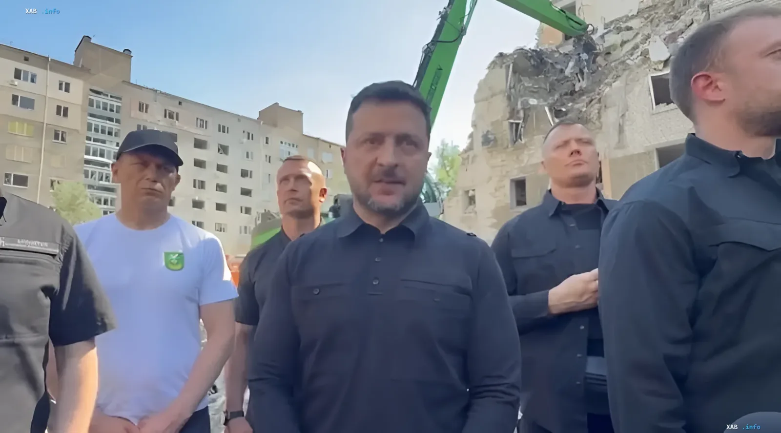 Президент Украины Владимир Зеленский осматривает разрушенное здание в Киеве на фоне работы техники, комментируя ситуацию с ПВО перед саммитом НАТО.