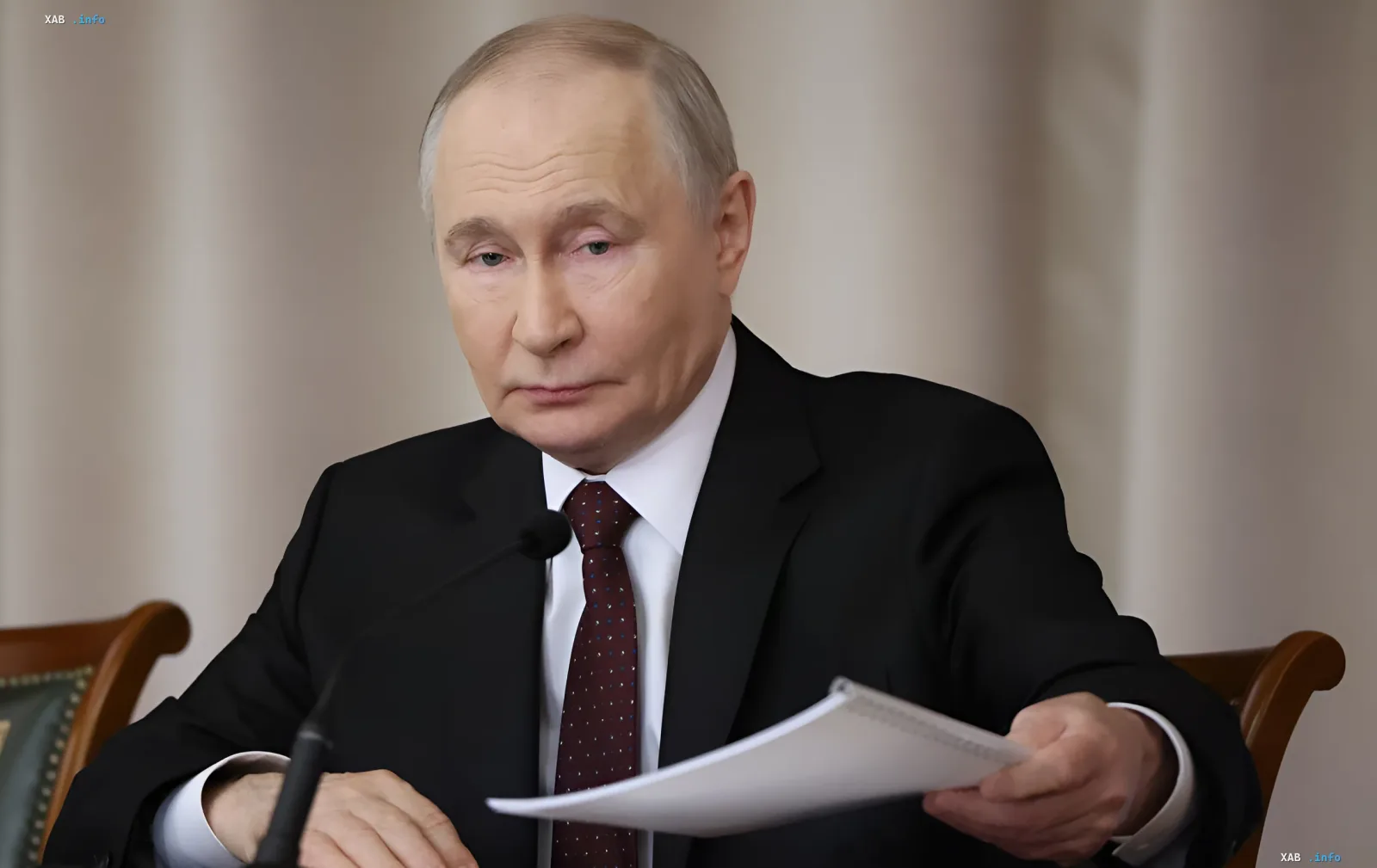 Владимир Путин за столом с документами, обсуждающий создание спецтрибунала в Гааге по агрессии против Украины
