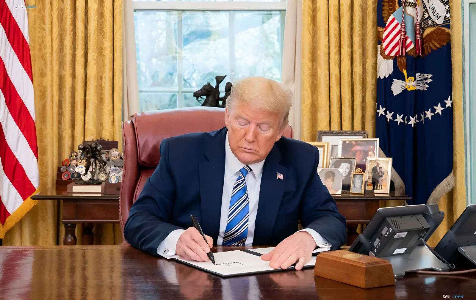 Дональд Трамп підписує документ за столом в Овальному кабінеті, ілюструючи новину про нову 100-доларову банкноту з його підписом