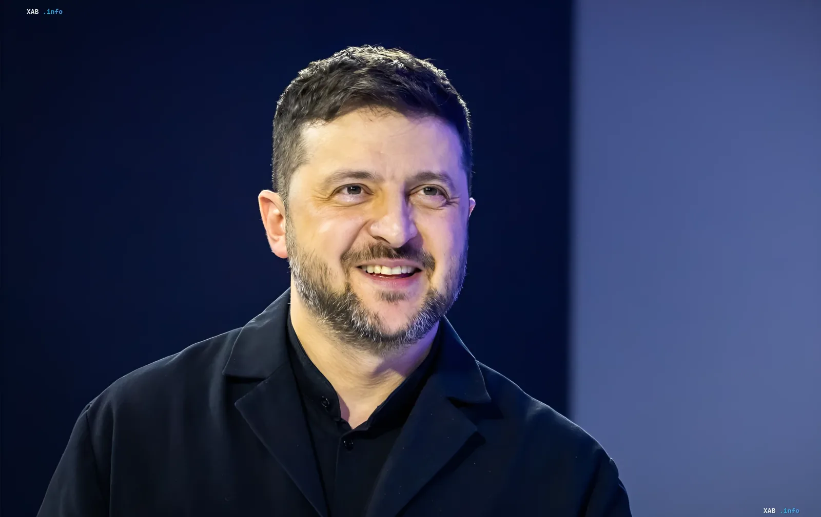 Ukrainian President Volodymyr Zelenskyy smiling against a blue background, discussing the return of initiative and Russia's defeat at sea.