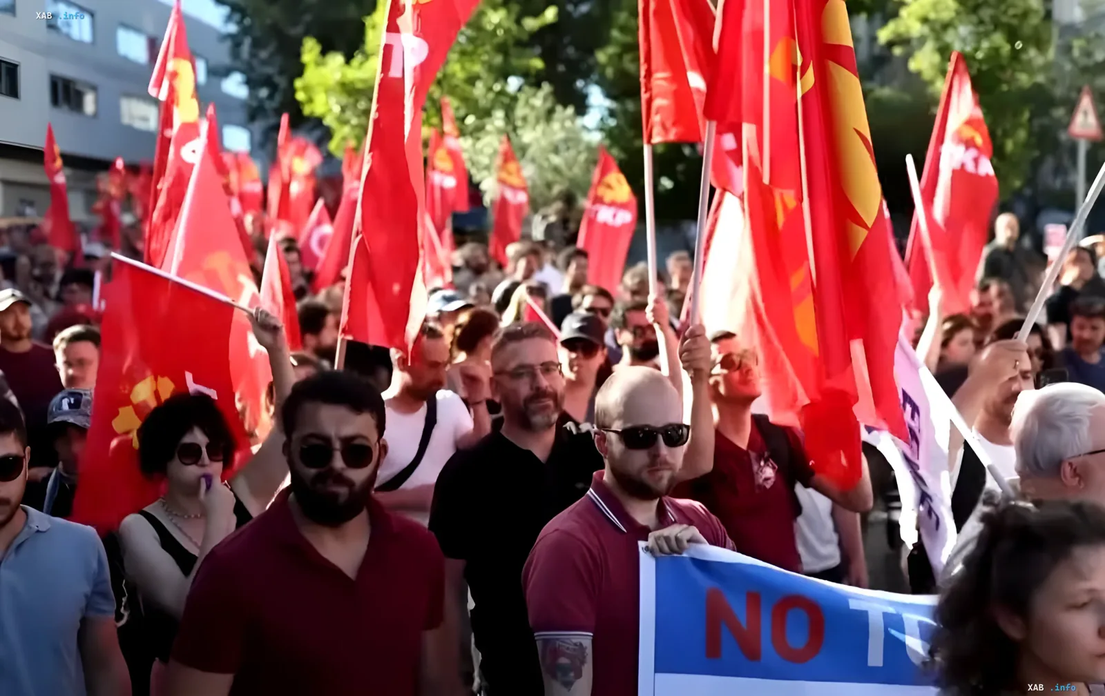 Демонстранты с красными флагами и лозунгами против НАТО на митинге в Турции перед саммитом