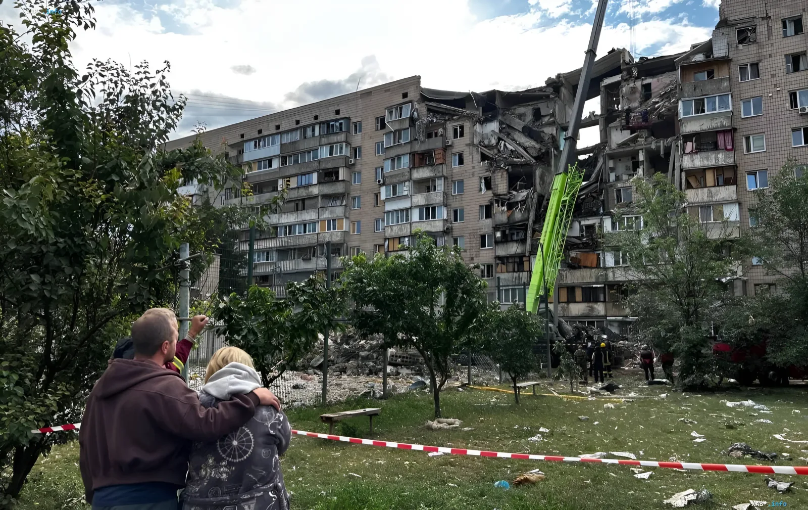 Разрушенный жилой дом после ракетного удара в Киеве или Вишневом, спасатели на месте, люди наблюдают за работой техники