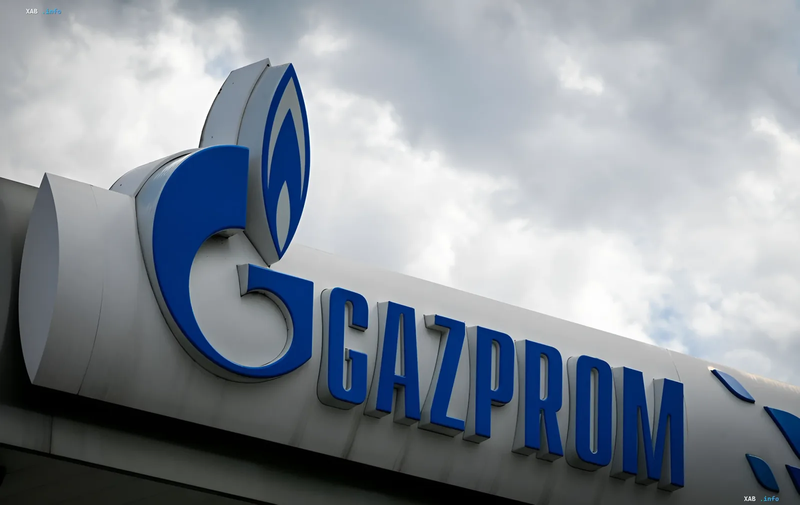 Логотип Газпрома на фоне облачного неба — символ компании, чьи акции рухнули до уровня кризиса 2008 года