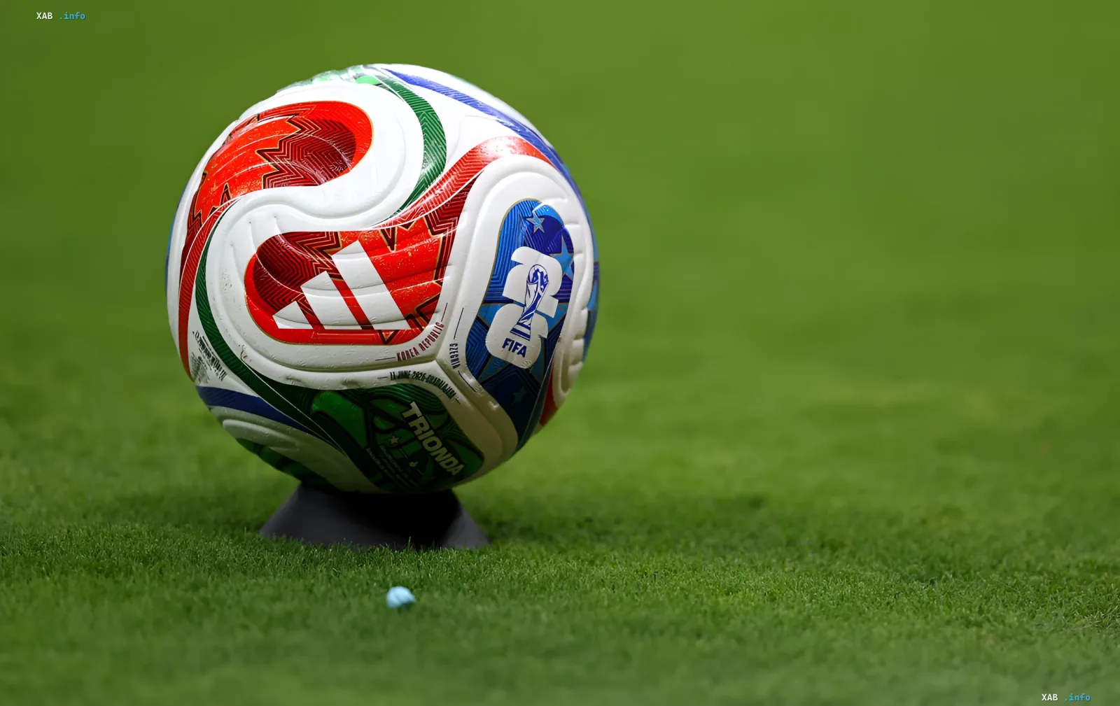 Футбольный мяч FIFA на зеленом газоне, символизирующий возвращение России на международные турниры после решения МОК