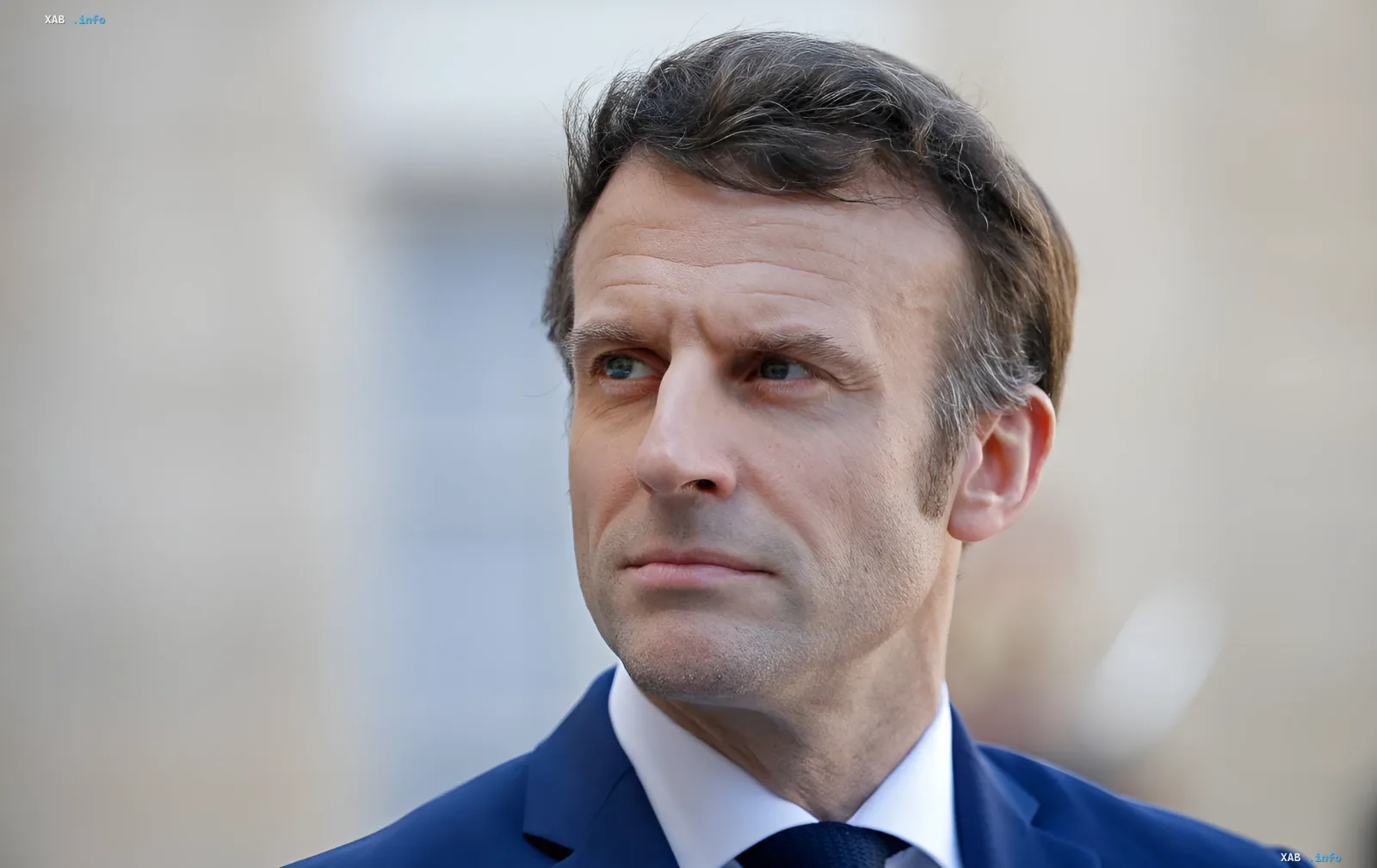 French President Emmanuel Macron in a business suit, discussing the return of artifacts and business opportunities in Damascus