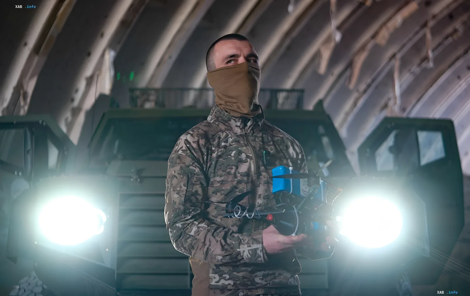 Украинский боец с дроном в камуфляже и маске на фоне военной техники — символ операции «Ашан»