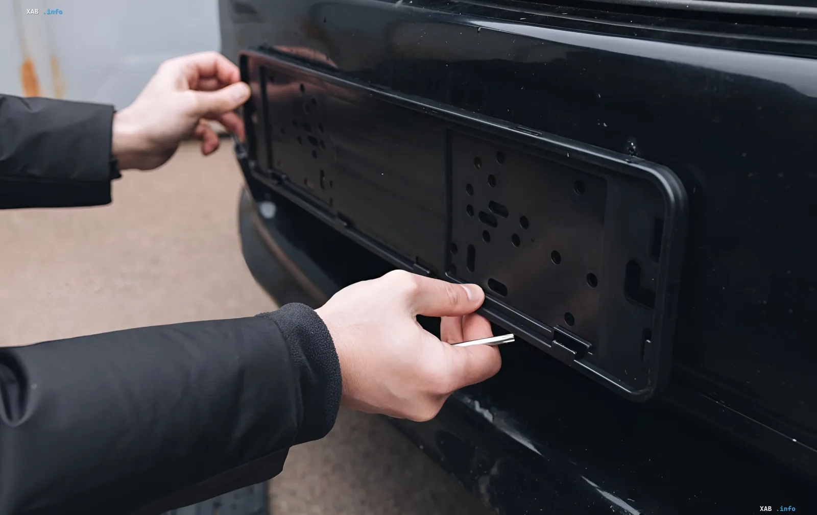 Person installing front license plate on car, illustrating debate over mandatory front plates in Ukraine