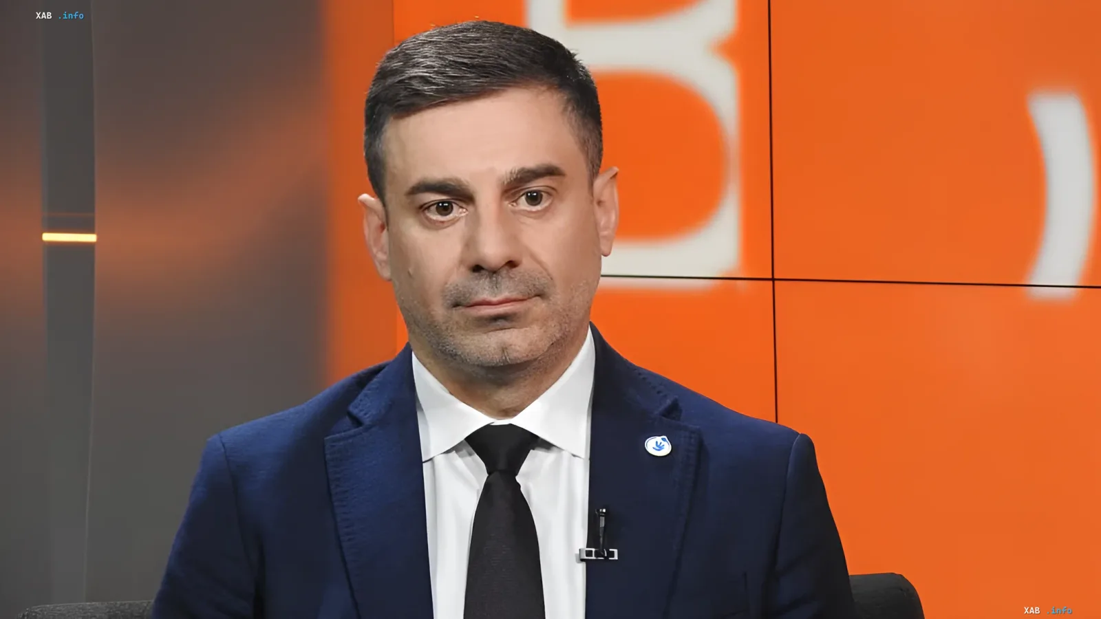 Single father at training center: man in business suit against orange screen discussing mobilization and family protection