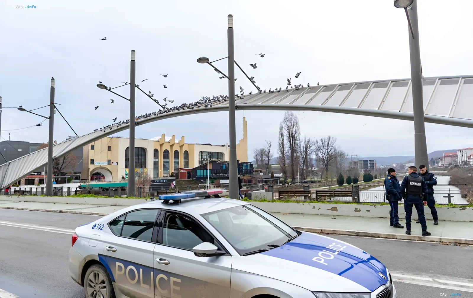 Полицейский автомобиль и офицеры на мосту, символизирующие задержание российских агентов с взрывчаткой на границе Сербии и Венгрии