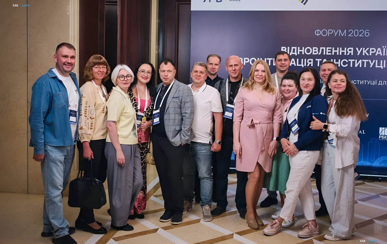 Учасники форуму «Відновлення України 2026» у Києві на фоні банера з темою податкової реформи та євроінтеграції