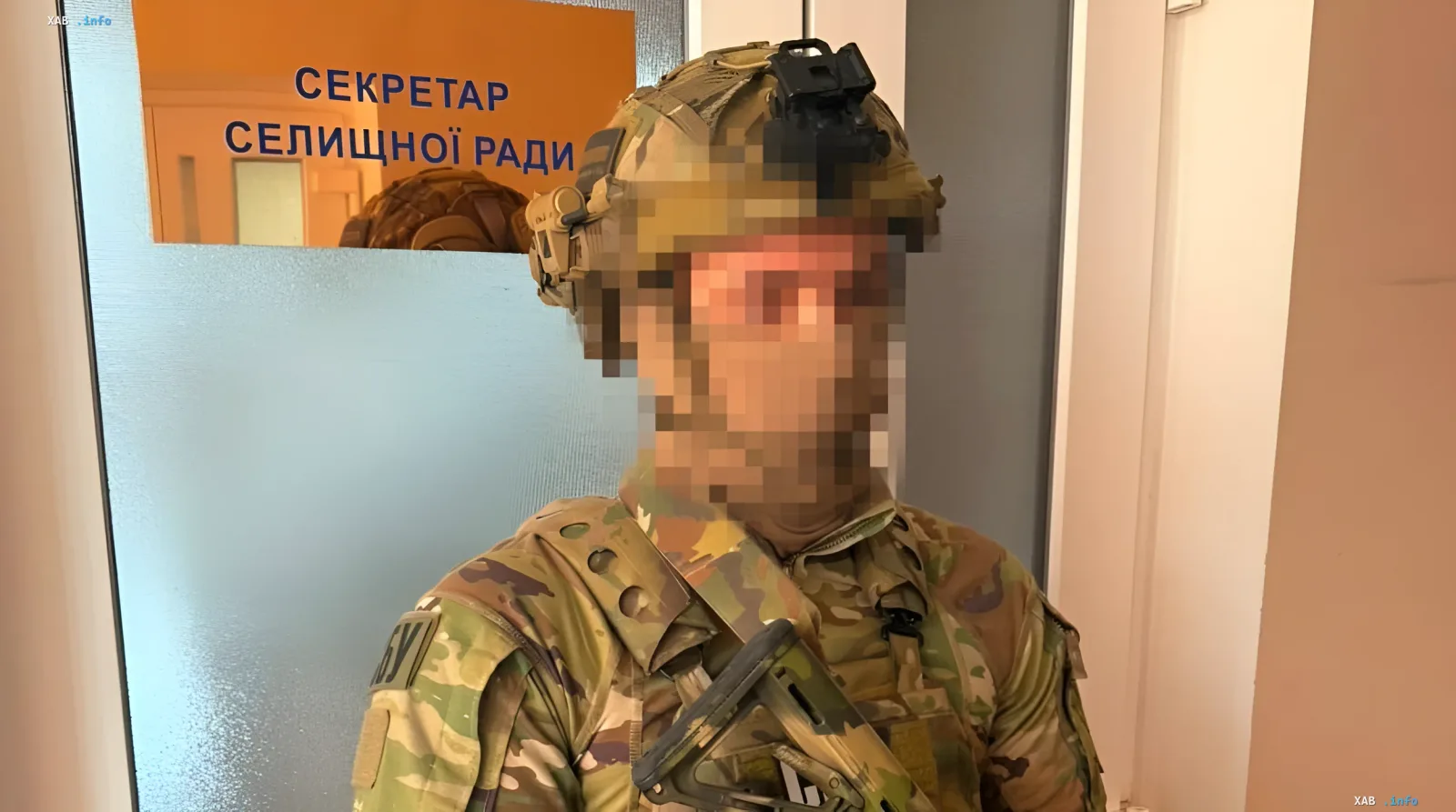 Военнослужащий в камуфляже стоит перед дверью с табличкой «СЕКРЕТАР СЕЛИЩНОЇ РАДИ» — место задержания первого замглавы облсовета Одессы при получении взятки