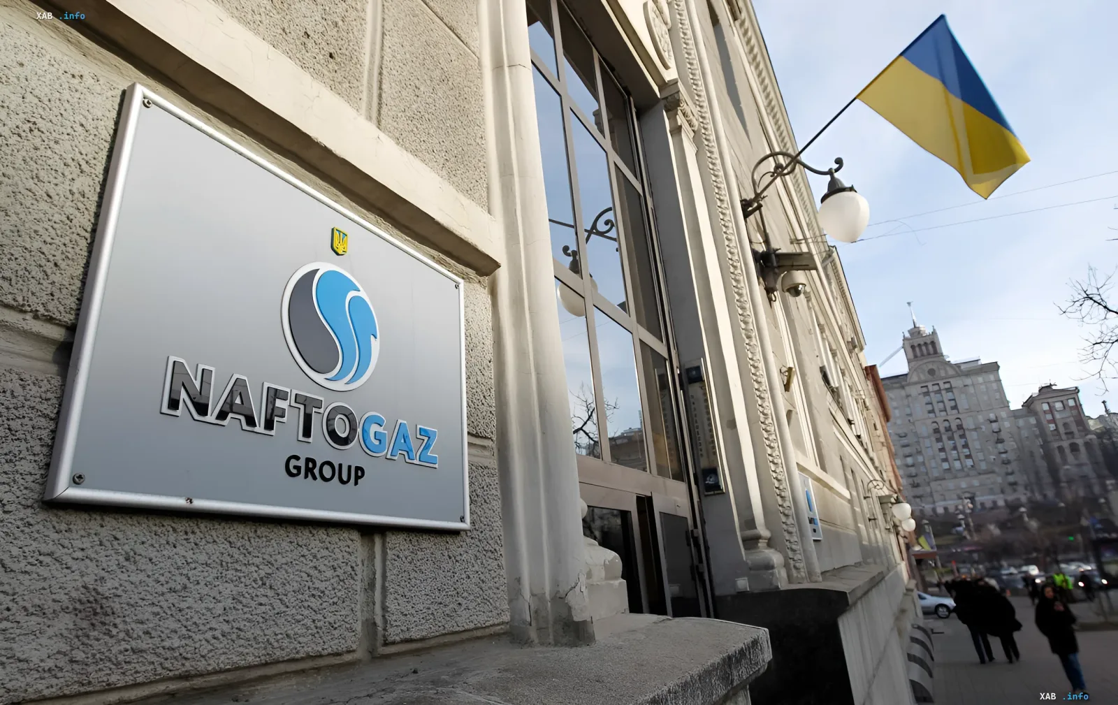 Логотип компании «Нафтогаз» на фасаде здания, флаг Украины на фоне, символизирующий готовность к ответным действиям в судебном споре с Казахстаном за 1,4 миллиарда долларов.