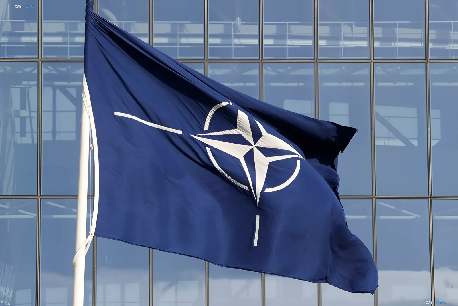 Прапор НАТО розвівається перед будівлею штаб-квартири, символізуючи затвердження нового плану перерозподілу військових сил в Європі
