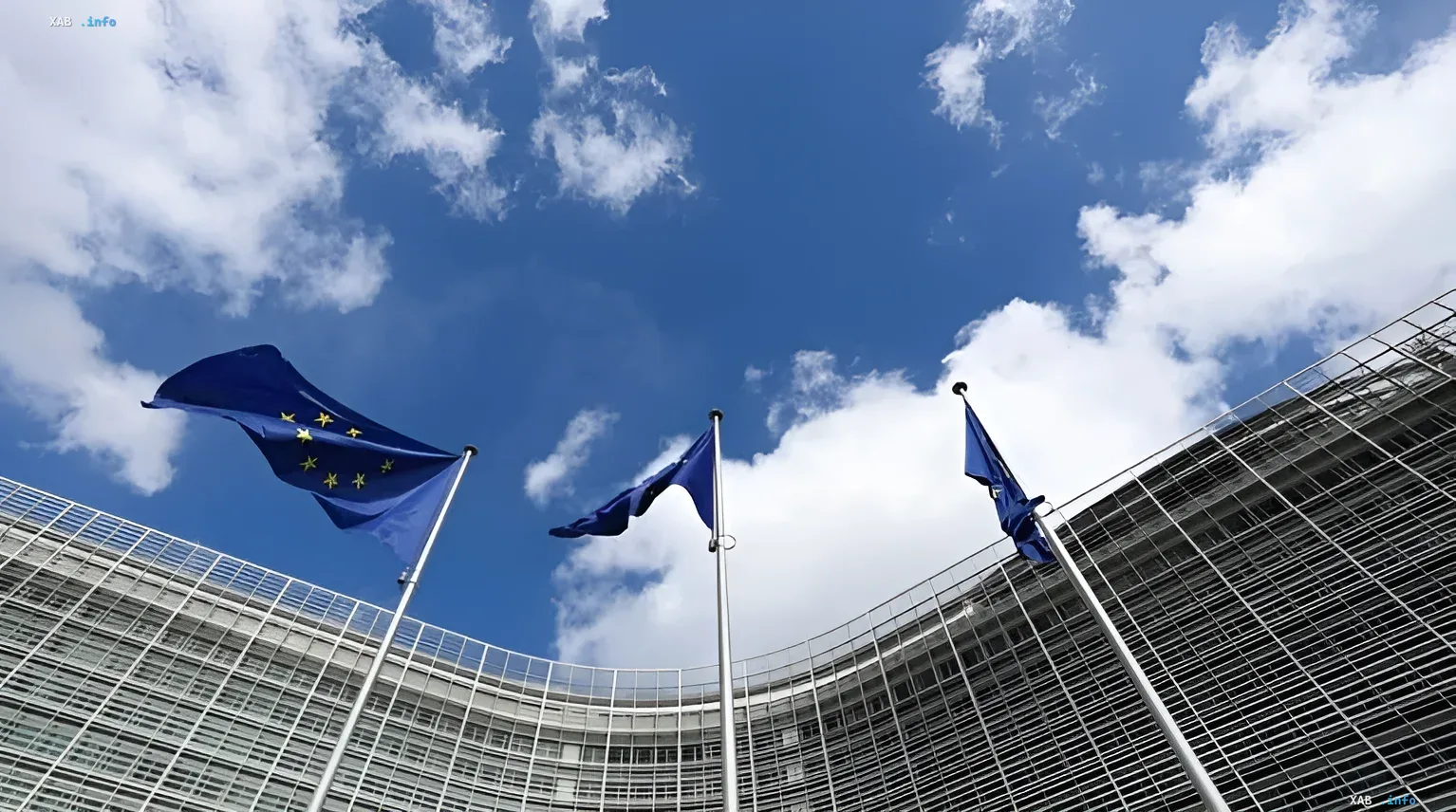 Флаги Европейского Союза перед зданием Европарламента на фоне голубого неба — символ кризиса в Шенгенской зоне из-за биометрического контроля