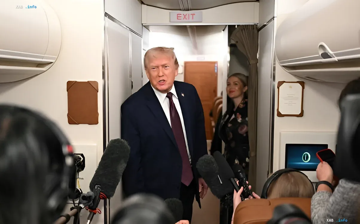 Donald Trump aboard an airplane, surrounded by journalists with microphones, discussing Greenland, Iran, and the new US military presence in Europe