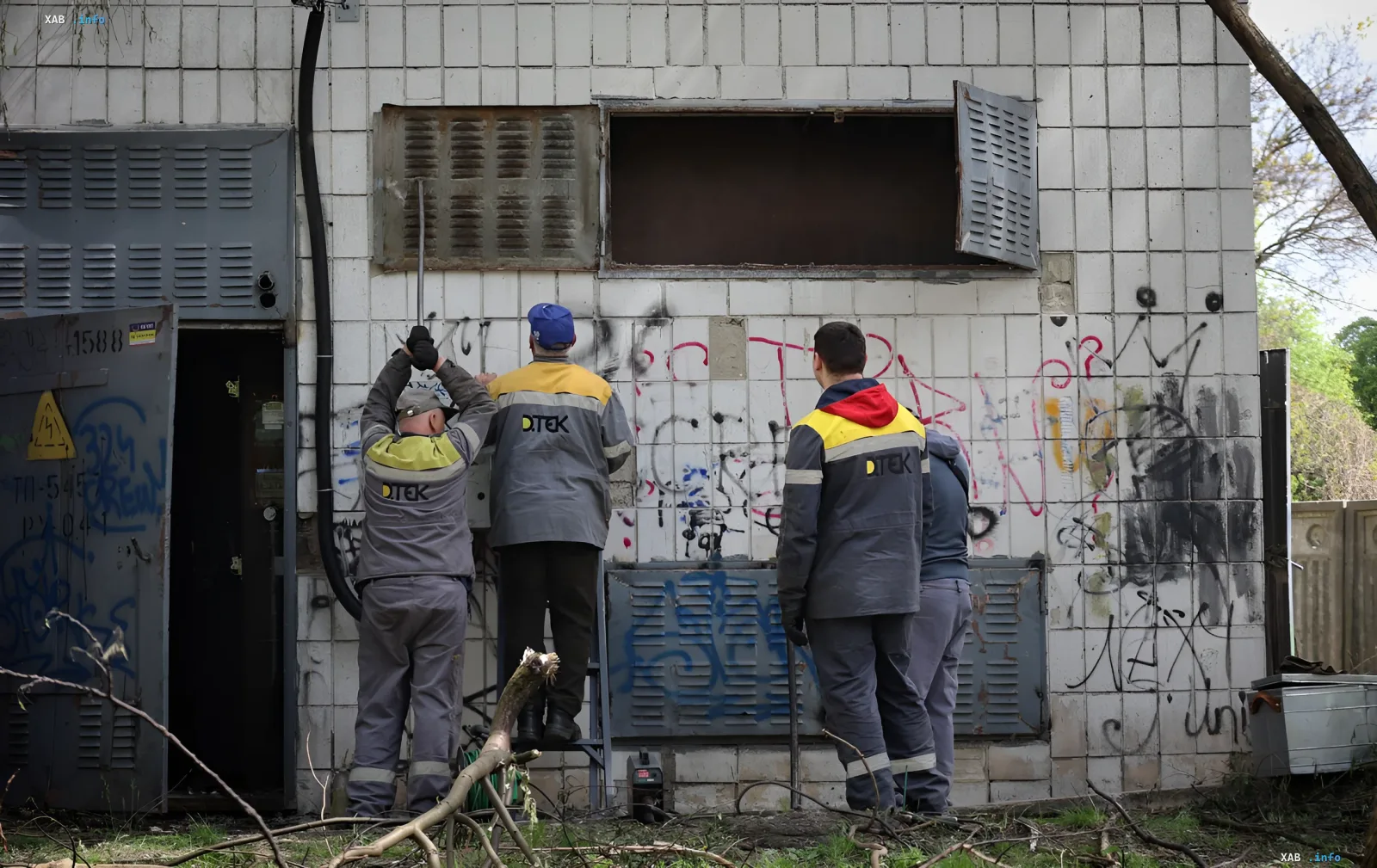 Arbeiter in DTEK-Uniformen stellen ein beschädigtes Gebäude nach Beschuss wieder her und demonstrieren die Arbeit nationaler Schnellreaktionsbrigaden